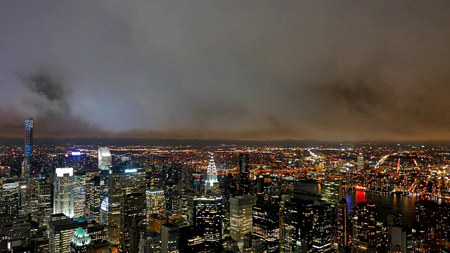 在夜晚，在城市大都市上空移动的云的时间流逝视频素材