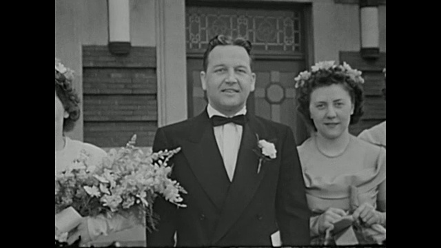 20世纪40年代的家庭电影——婚礼派对和客人们在教堂外摆姿势拍照视频素材