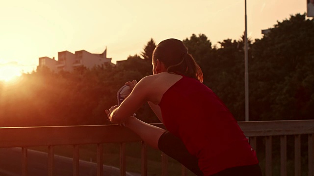 SLO MO女跑步者伸展她的腿在日落视频素材