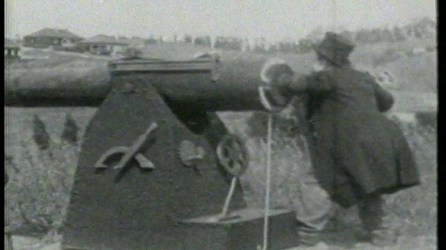 1915年，一名男子(切斯特·康克林)在草山附近发射大炮视频素材