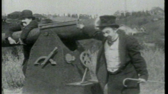 1915年，一个人在大炮前对着屏幕外的人大喊/第二个人靠在大炮上/特写视频素材