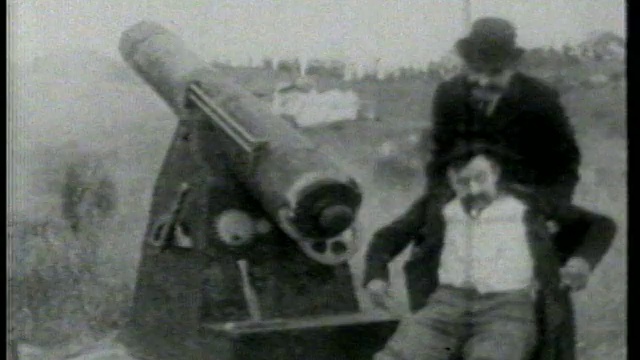 1915年，一名男子在草坡上的大炮旁拍打着第二名男子的脸视频素材