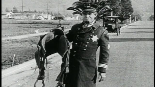 1924年B/W Keystone Kop (Will Rogers)拿着马鞍+试图骑上不再有的马视频素材
