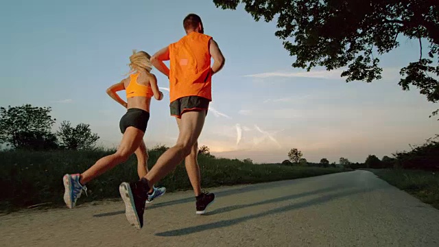 SLO MO TS男人和女人在日落奔跑视频下载