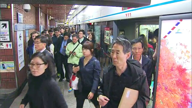 人们在首尔站和电子显示屏上上下地铁视频素材