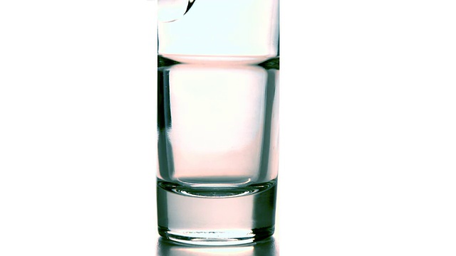 水倒进白色背景的玻璃杯中视频素材