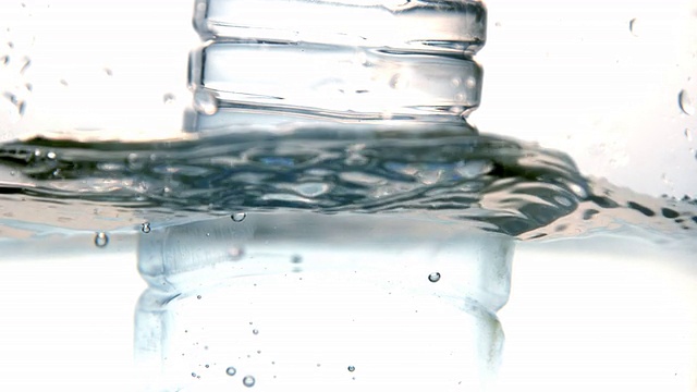 塑料瓶落在白色背景的水中视频素材