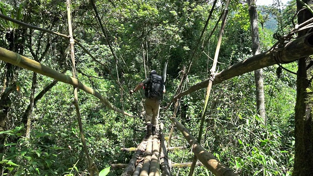 一个徒步旅行者的脚在缅甸丛林的脚桥上的特写视频下载