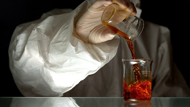 科学家将红色液体倒入烧杯视频素材