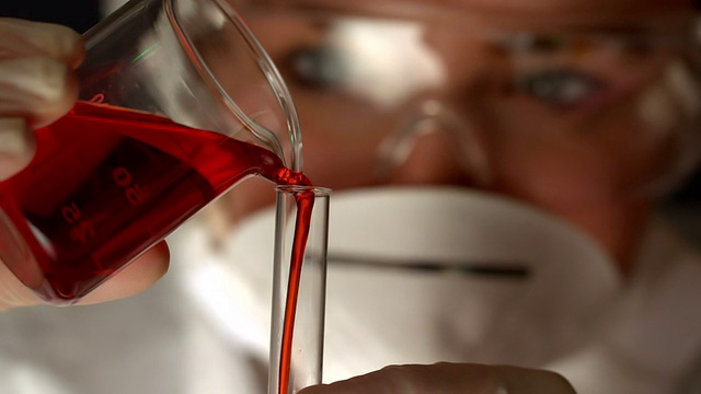 科学家将红色液体倒入试管视频素材