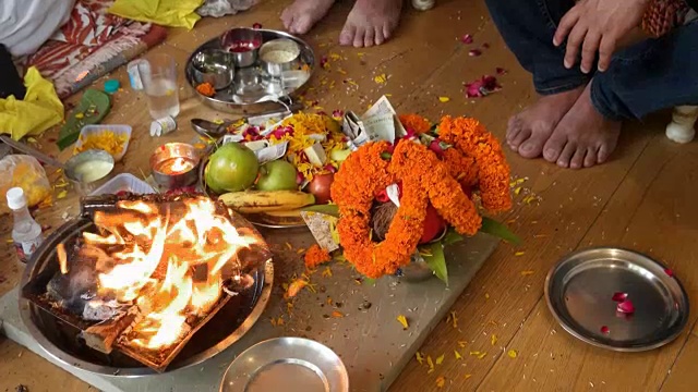 两名男子在燃烧的火焰中提供宗教供品，这是印度教祈祷和礼拜活动的一部分，在家里进行，由祭司或“Pujari”进行视频素材