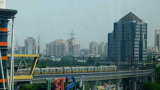 在古尔冈HUDA地铁站前，两列德里地铁交错在一起，城市的天际线在后面视频下载