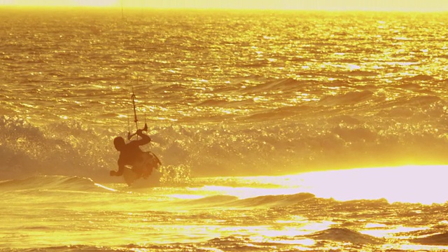 长焦镜头拍摄的几个风筝冲浪者在行动中日落视频下载