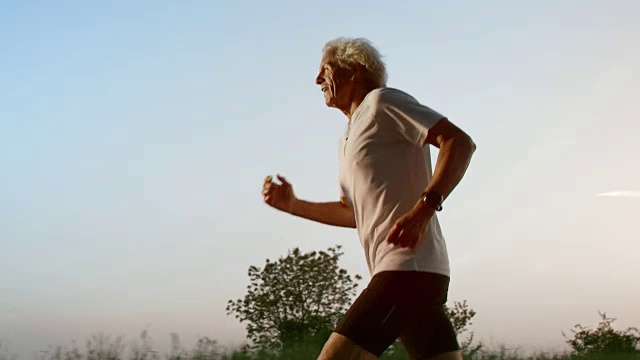 SLO MO TS在日落奔跑的年长男性视频素材
