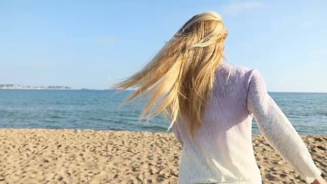 美丽的金发女人在海滩上享受视频素材