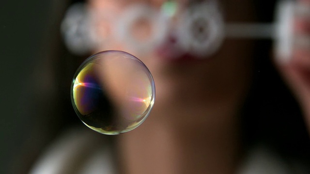 吹泡泡的女人专注于一个泡泡视频素材