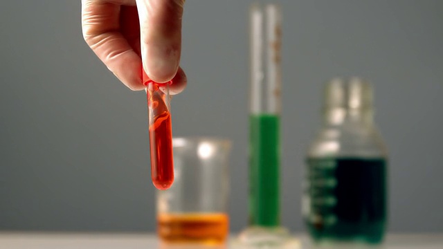 科学家旋转着红色化学物质的试管视频素材