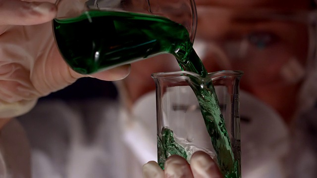 科学家将绿色液体倒入烧杯视频素材