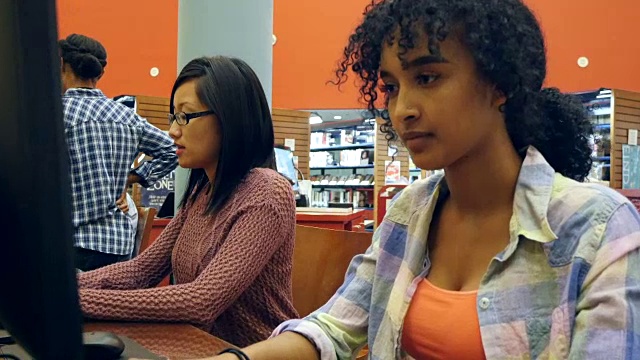 一名年轻的非裔美国大学生在图书馆计算机实验室勤奋工作视频素材
