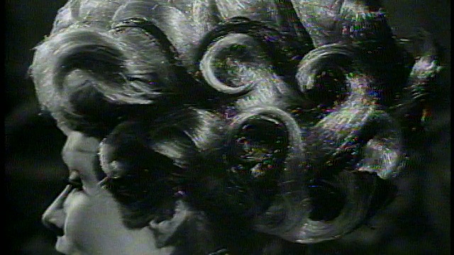 1965年B/W近距离缩小模型与非凡的卷发转向相机/新闻胶片视频下载