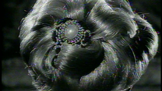 1965年B/W近距离模特与非凡的发型转向相机/放大夹在头发/新闻胶片视频下载