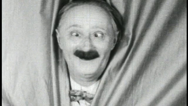 1928年黑白近景，斜眼男子(本·特平)从窗帘/短裤中向外张望视频素材