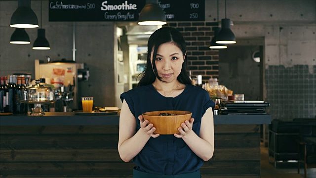骄傲的亚洲女孩展示一碗新鲜的食物视频素材