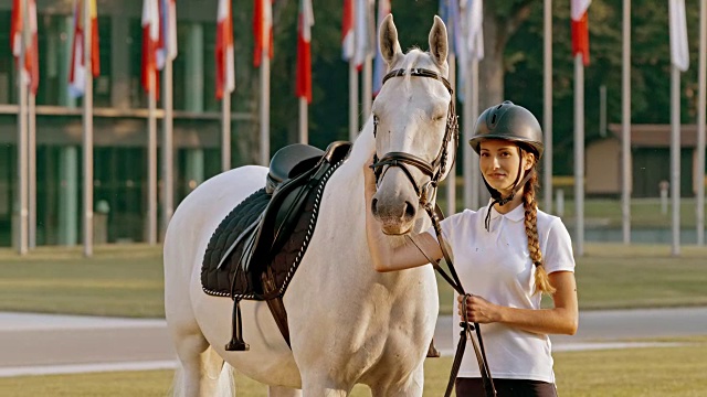 一个女人和她的马在一个骑马学校前面的肖像视频下载