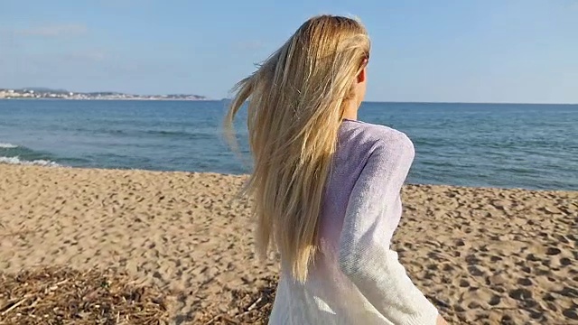 一个留着长发的年轻女子在海滩上奔跑视频下载