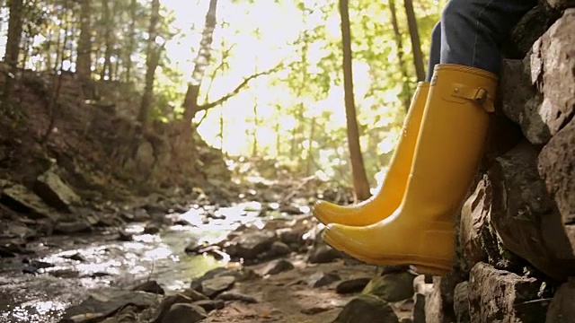 一个白人女人在小溪边踢雨靴视频下载