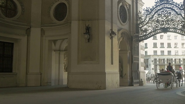 马车远离镜头穿过罗马拱门，米夏勒广场。从L到r，中距离射击。视频素材