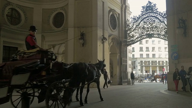 马车远离镜头穿过罗马拱门，米夏勒广场。从L到r宽频。视频素材