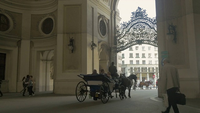 马车远离镜头穿过罗马拱门，米夏勒广场。从L到r宽频。视频素材