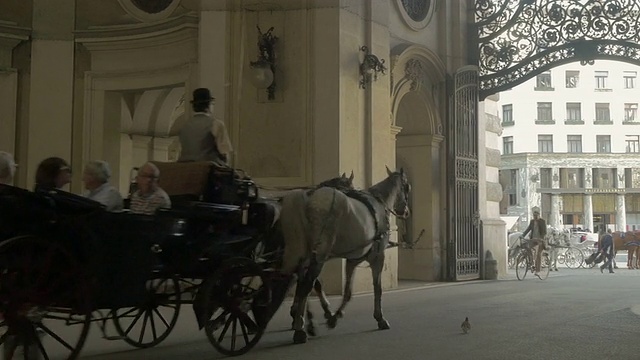自行车和马车远离镜头通过罗马拱门，米夏勒广场。从L到r宽频。视频素材