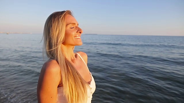 女人微笑着走在海滩上视频素材
