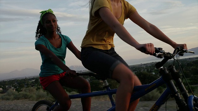 跟踪中拍摄的年轻女性骑双人自行车/雪松山，犹他州，美国视频素材