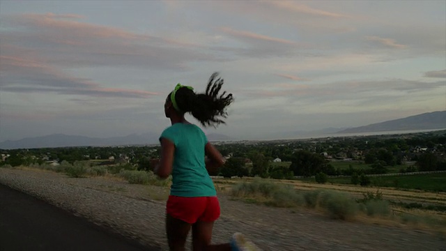 跟踪中镜头的少女跑在公路/雪松山，犹他州，美国视频素材