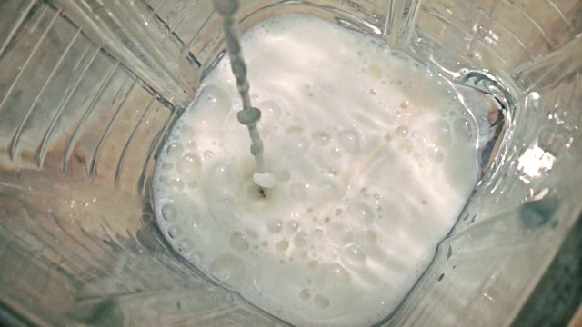 在搅拌机里倒入牛奶，慢动作视频素材