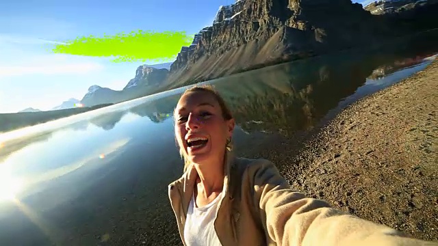 年轻女子与壮观的山湖风景自拍视频素材