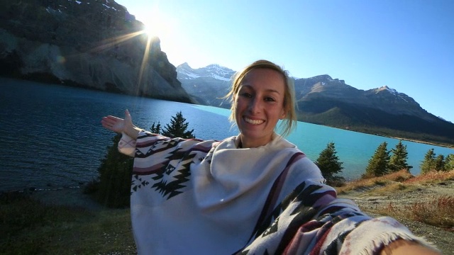 一个快乐的年轻女子在湖边自拍视频素材