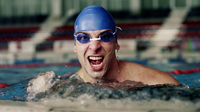 年轻的男子游泳运动员在泳池里欢呼视频素材