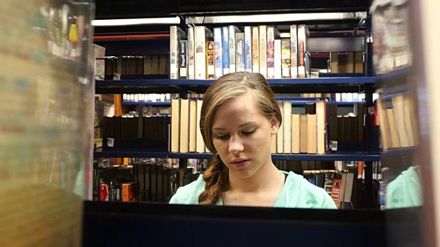 漂亮的女性白人家庭学校高中学生搜索在公共图书馆的书视频下载