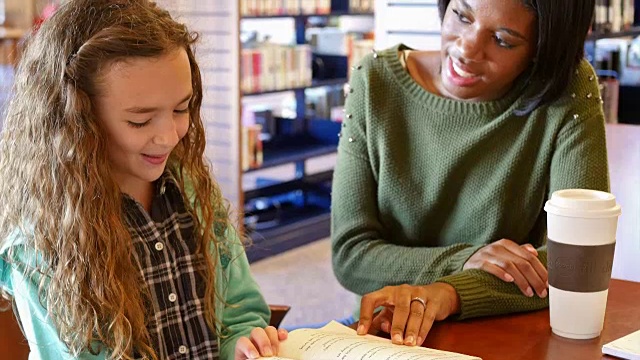 非裔美国教师在学校或公共图书馆辅导小学生视频素材