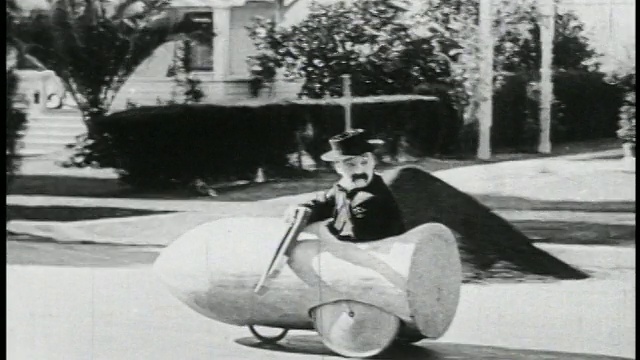 1923年B/W男人(冷落波拉德)在微型汽车和巨大的磁铁沿着街道移动视频下载