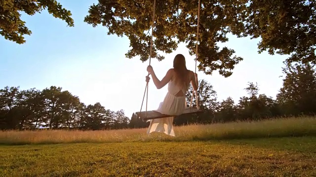 SLO MO女人在白色连衣裙摆动向太阳视频素材