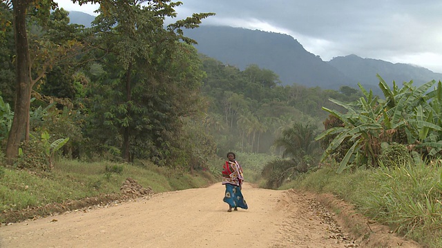 一个女人走在非洲一条偏僻的土路上视频下载
