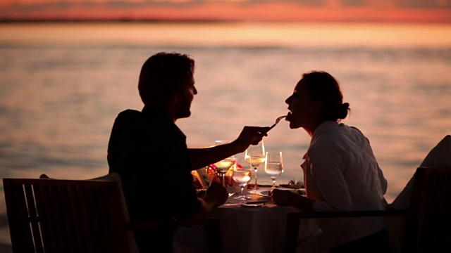 一对情侣在日落时分的海滩上用餐视频下载