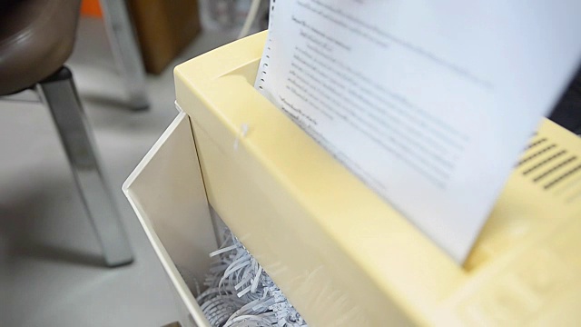 摇纸:纸张在旧碎纸机中放入和取出视频素材