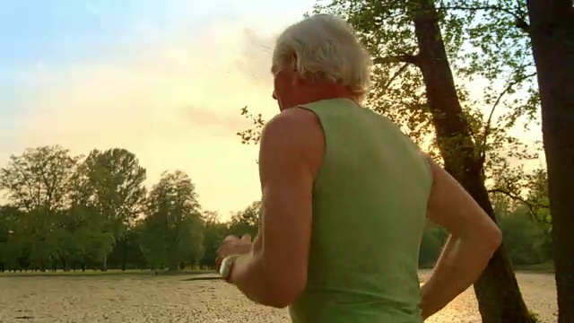 日落时分，一位老人在湖边跑步视频素材