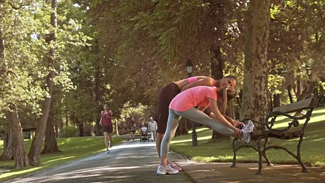 妈妈在公园里教女儿做伸展运动视频素材